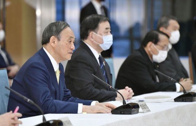 12일 스가 요시히 데 일본 총리가 도쿄 관저에서 열린 내각 회의를 주재하고 있다.  AP=뉴시스