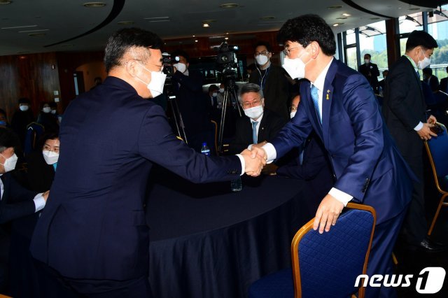 윤호중(왼쪽), 박완주 더불어민주당 원내대표 후보자가 14일 오전 서울 여의도 마리나클럽에서 열린 더불어민주당 초선의원 모임 ‘더민초’의 초청토론회에서 악수하고 있다. 2021.4.14/뉴스1 © News1