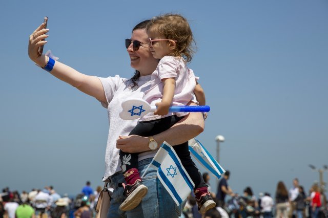지난 15일(현지시간) 이스라엘 텔아비브 해변에서 마스크를 쓰지 않은 엄마와 딸이 기념 밝게 웃으며 기념 사진을 촬영하고 있습니다. AP 뉴시스