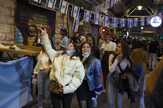14일(현지시간) 예루살렘 야하나 예후다 시장에서 마스크를 벗은 젊은이들이 독립기념일을 축하하며 밝게 웃고 있습니다. AP 뉴시스