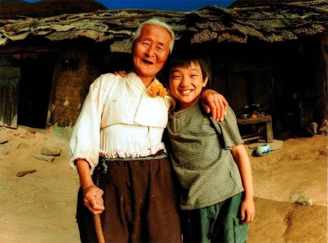 2002년 개봉한 영화 ‘집으로…’에서 할머니 역을 맡은 김을분 할머니(왼쪽)와 일곱 살 손자를 연기한 배우 유승호. 충북 영동군 상촌면 지통마 마을을 배경으로 촬영했다. 팝엔터테인먼트 제공