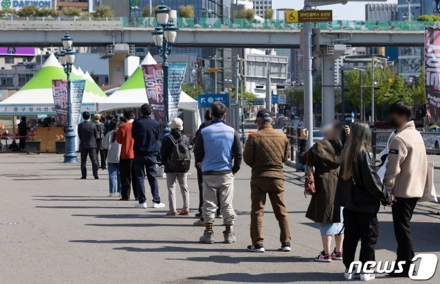 18일 오전 서울 중구 서울역광장에 마련된 임시선별진료소를 찾은 시민들이 검사를 받기 위해 줄을 서 있다. 2021.4.18/뉴스1 © News1