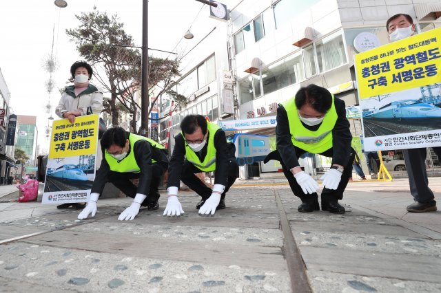 지난달 15일 충북 청주 옛 도심 철길에서 열린 ‘청주도심 통과 충청권 광역철도 반영을 위한 삼보일배’ 마지막 챌린지 행사에서 이시종 충북지사(가운데) 등 참가자들이 절을 하고 있다. 충북도 제공