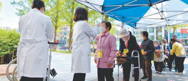 19일 광주 북구 용봉동 예방접종센터 앞에서 북구청 공무원 등이 코로나19 백신 접종에 앞서 75세 이상 고령자들의 체온을 재고 있다. 광주=뉴시스