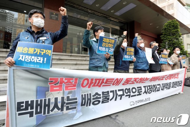 전국택배노조 조합원들이 20일 서울 중구 CJ대한통운 본사 앞에서 기자회견을 열고 택배차량의 지상도로 출입을 전면 금지한 고덕동 아파트를 배송불가 구역으로 지정해줄 것을 촉구하고 있다. 2021.4.20/뉴스1 © News1