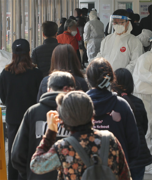 20일 시민들이 서울 동대문구 보건소에 설치된 선별진료소에서 코로나19 검사를 받기 위해 줄을 서 기다리고 있다. 뉴스1