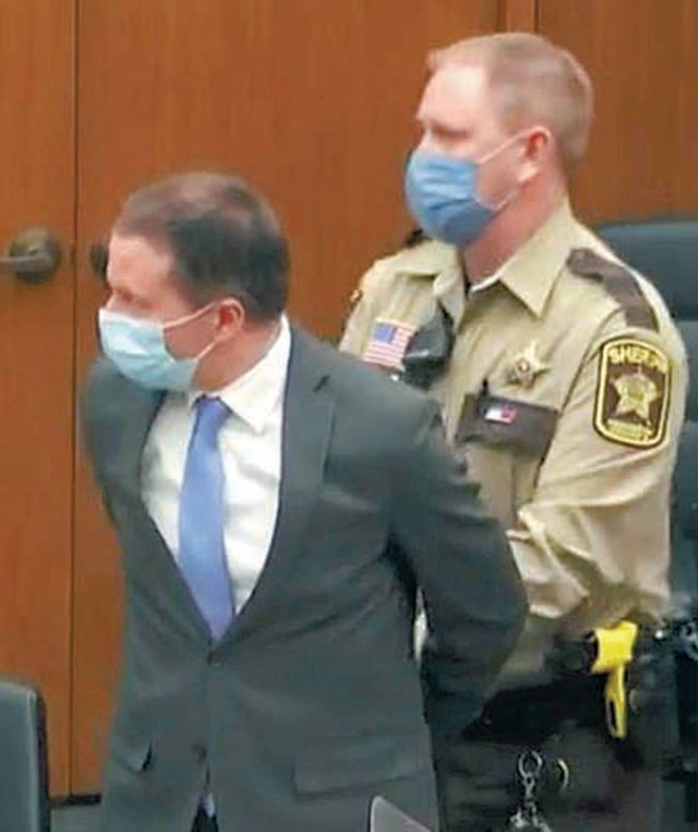 마스크를 쓰고 양복을 입은 채 재판에 출석한 데릭 쇼빈 전 경관이 유죄 평결 직후 뒤로 수갑을 찬 채 경찰에 연행되고 있다.