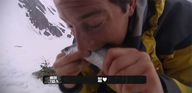 영국 탐험가 베어 그릴스가 생선을 먹기 전 흐뭇해하는 속마음이 “헿♥”이라는 자막으로 표현됐다. 사진 출처 유튜브 채널 ‘디스커버리 서바이벌’