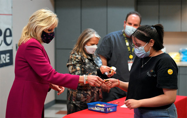 백신 접종자에 핀배지 건네는 美 퍼스트레이디 조 바이든 미국 대통령의 부인 질 바이든 여사(왼쪽)가 21일(현지 시간) 뉴멕시코주 앨버커키에 있는 백신접종센터를 방문해 코로나19 백신을 맞은 주민에게 핀배지를 건네주고 있다. 앨버커키=AP 뉴시스