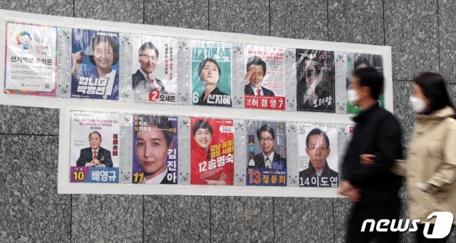 지난 4일 서울 중구 명동성당 앞에서 시민들이 서울시장 후보 벽보를 보며 발걸음을 옮기고 있다. 2021.4.4 © News1 황기선 기자