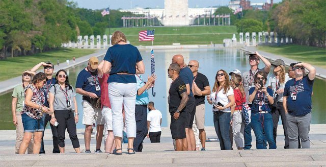 27일(현지 시간) 미국 워싱턴 링컨기념관 ‘반사의 연못(reflecting pool)’ 앞에 마스크를 쓰지 않은 관광객들이 모여 있다. 워싱턴=AP 뉴시스