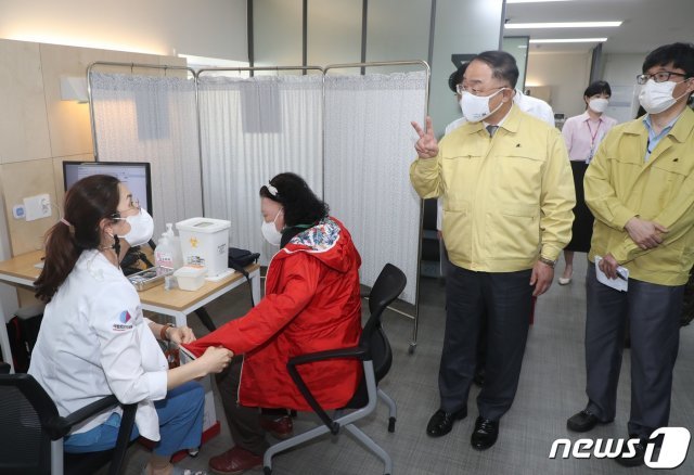 홍남기 국무총리 직무대행이 29일 오후 서울 중구 국립중앙의료원 중앙예방접종센터를 방문, 백신 접종을 지켜보며 의료진과 대화하고 있다. 2021.4.29/뉴스1 © News1