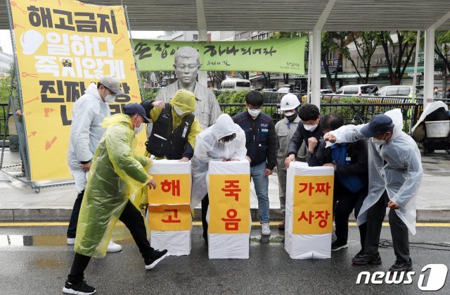 근로자의 날인 1일 오후 서울 종로구 전태일 동상 앞에서 비정규직 이제그만 공동투쟁 회원들이 ‘해고 금지, 비정규직없는세상’ 2021 비정규직 행진에 앞서 상징 의식을 하고 있다. 2021.5.1/뉴스1 © News1