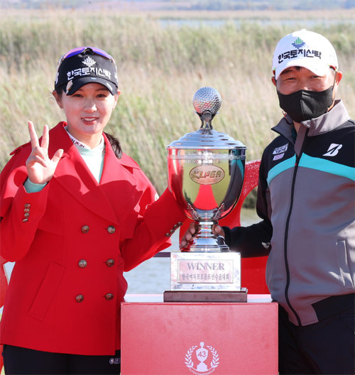 박현경(왼쪽)이 2일 크리스F&C KLPGA 챔피언십 시상식에서 캐디인 아버지 박세수 씨와 함께 트로피를 든 채 통산 3승을 의미하는 손가락 3개를 들어 보이고 있다. KLPGA 제공