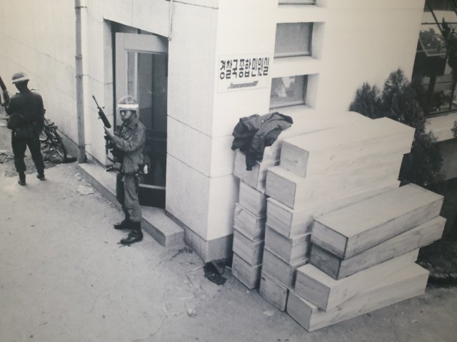 노모 소프 전 아시아월스트리트저널 기자가 1980년 5월 27일 오전 8시경 전남도청에 진입한 계엄군들이 전남경찰국 앞에서 경계를 서고 있는 모습을 촬영했다. 당시 계엄군들 주변에는 나무관이 놓여있다.