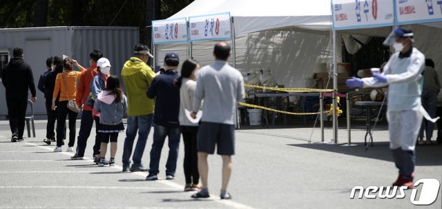 울산지역에 신종 코로나바이러스 감염증(코로나19) 변이 바이러스 확산세가 이어지고 있는 5일 울산 남구 문수축구경기장에 마련된 임시 선별검사소를 찾은 시민들이 검사를 받기 위해 줄지어 서 있다. 2021.5.5/뉴스1 © News1