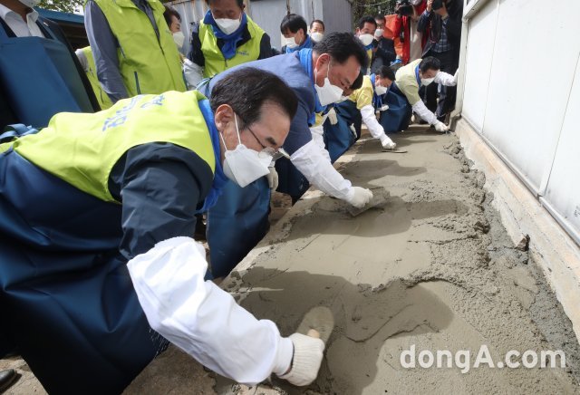 이성희 농협중앙회장(왼쪽)을 비롯한 사랑의 집 고치기 농가희망봉사단원들이 7일 충남 당진시 관내 농가를 찾아 미장작업을 하고 있다. 농협 제공
