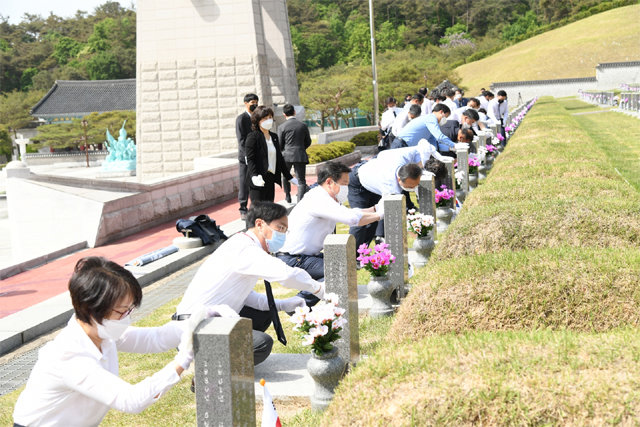 김병내 광주 남구청장과 공무원들이 6일 광주 북구 운정동 국립5·18민주묘지 참배를 한 뒤 묘비 닦기 등 정화활동을 펼치며 오월 정신을 되새기고 있다. 광주 남구 제공