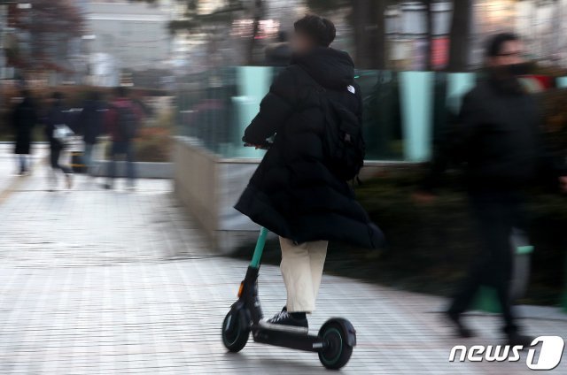 서울 광화문 사거리에서 한 시민이 전동킥보드를 타고 있다. 2020.12.9/뉴스1 © News1