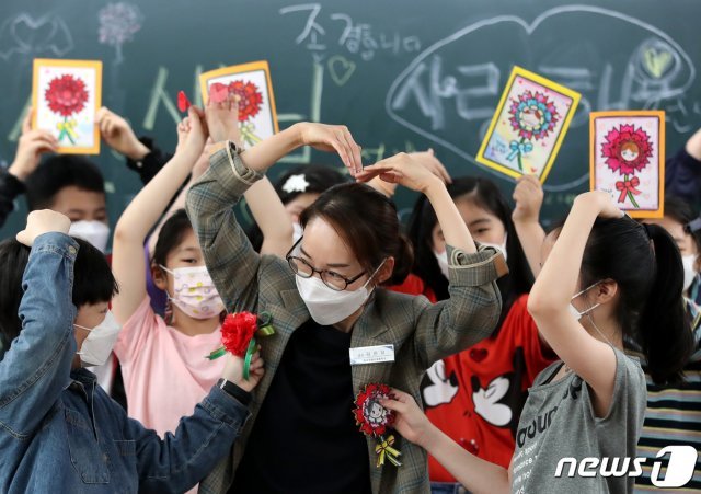 스승의 날을 하루 앞두고 14일  대전 한 초등학교에서 교사가 학생들에게 카네이션을 받고 있다. 2021.5.14/뉴스1 © News1
