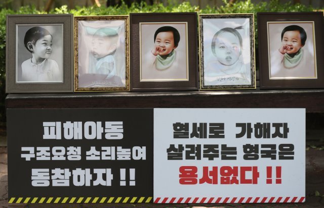 피해아동 구조요청 소리 높여 동참하는 손팻말과 정인이를 추모하는 사진이 법원 담장 앞에 놓여있다.