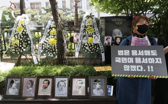 “법은 용서해도 국민이 용서하지 않겠다” 법원 앞에서 한 시민이 피켓을 들고 양모 정씨의 사형 선고를 촉구하고 있다.