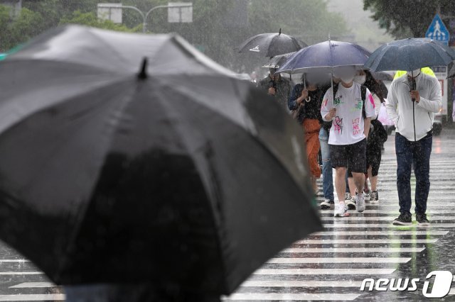 주말 전국에 비가 예고된 15일 오후 서울 광화문 네거리에서 시민들이 비를 피해 발걸음을 재촉하고 있다. 2021.5.15/뉴스1 © News1