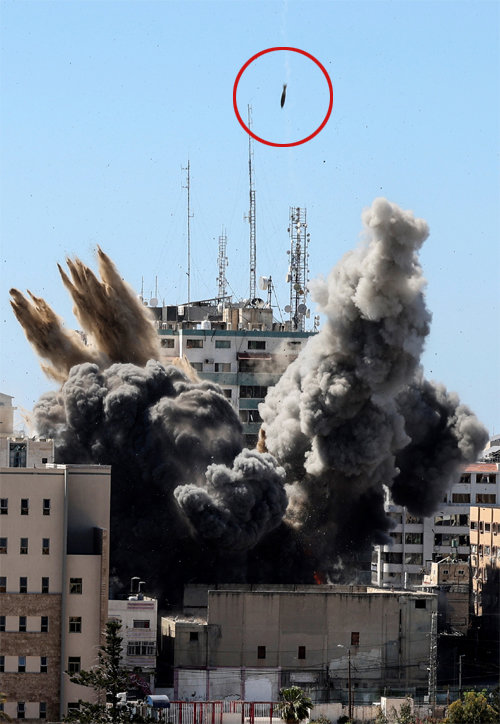 15일(현지 시간) 이스라엘군의 공습을 받은 팔레스타인 자치령 가자지구 내 ‘잘라 타워’에서 연기가 솟아오르는 가운데 뒤이어 다른
 포탄(점선 안) 하나가 또 떨어지고 있다. 이 건물에는 AP통신, 카타르 국영 방송 알자지라 등 다수의 언론사가 입주해 있었다.
 이스라엘군은 공습 1시간 전 건물주에게 “공습의 표적이 될 수 있으니 1시간 안에 모두 대피하라”고 밝혀 인명 피해는 없었다. 
가자=AP 뉴시스