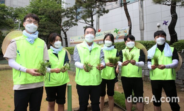 17일 
서울시 중구 농업박물관 앞 체험농장에서 열린 손모내기 행사에서 이성희 농협중앙회장(왼쪽에서 
세 번째)와 신규직원들이 기념촬영을 하고 있다.