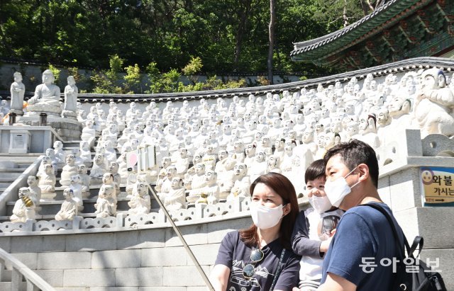 18일 인천 강화군 보문사를 찾은 한 가족이 오백나한상을 배경으로 기념사진을 찍고 있다. 강화=양회성 기자