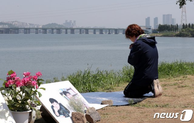 지난 19일 서울 반포한강공원 택시 승강장 인근에 마련된 고 손정민씨 추모 공간을 찾은 한 시민이 무릎을 꿇은 채 기도하고 있다. 한편 고 손정민씨의 사망 경위에 대한 수사가 이어지는 가운데 경찰은 실종 당일 오전 ‘한 남성이 한강에 입수하는 것을 목격했다’는 제보를 받아 사실관계를 확인하고 있다. 경찰은 전날(18일) 새벽 직접 현장을 찾았지만, 입수자의 신원은 아직 확인되지 않았다. 이에 수사력을 모아 신원 확인에 주력하는 한편 추가 목격자 확보와 함께 주변 폐쇄회로 분석을 계속 벌이고 있다. © News1 박지혜 기자