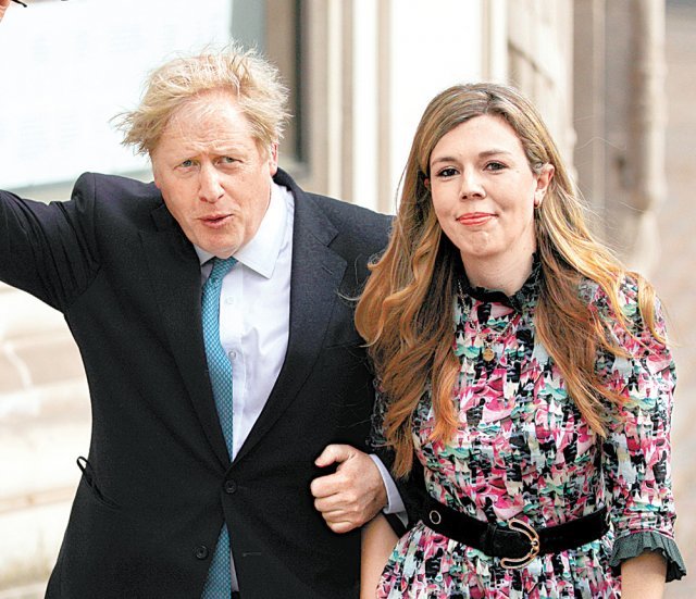 보리스 존슨 영국 총리(왼쪽)가 이달 6일(현지 시간) 약혼자인 캐리 시먼즈의 팔짱을 낀 채 영국 런던의 지방의회 선거 투표소에 들어서고 있다. 런던=AP 뉴시스
