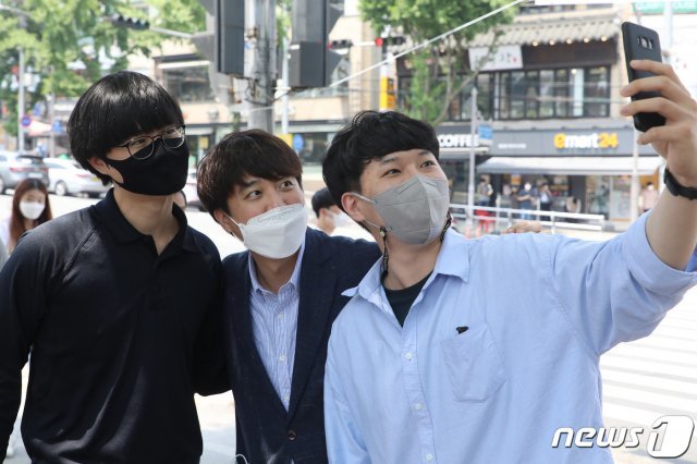 국민의힘 당 대표 출마를 선언한 이준석 전 최고위원이 24일 오후 대구 북구 경북대학교 북문 앞에서 대학생들과 인사 나누며 기념사진을 찍고 있다. 2021.5.24/뉴스1 © News1