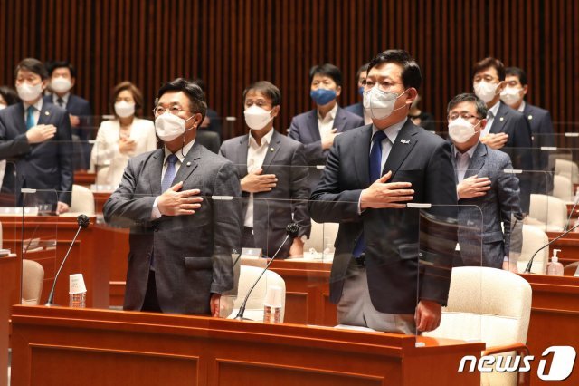 더불어민주당 송영길 대표와 윤호중 원내대표가 25일 오전 서울 여의도 국회에서 열린 의원총회에 참석해 국기에 대한 경례를 하고 있다. 2021.5.25/뉴스1 © News1