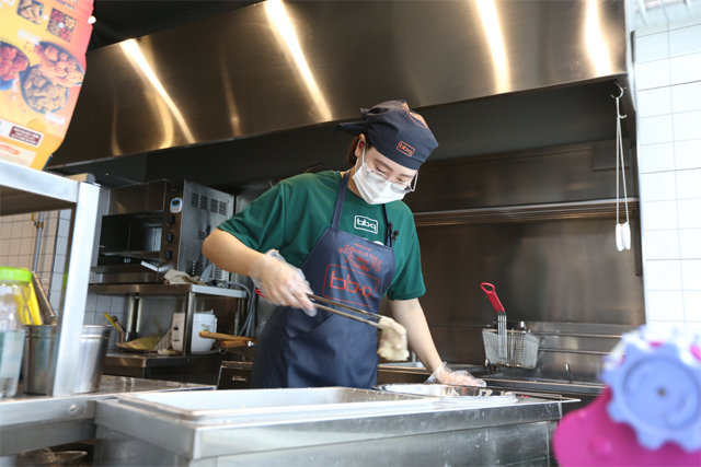 BBQ 스마트 키친(BSK)의 한 점주가 자신의 점포에서 치킨 조리를 하고 있다. 제너시스BBQ 제공