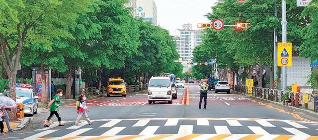 인천 서구 검암동 간재울초등학교 앞 도로에 설치된 횡단보도에서 경찰관이 길을 건너는 어린이들을 위해 교통지도 활동을 벌이고 있다. 인천경찰청 제공