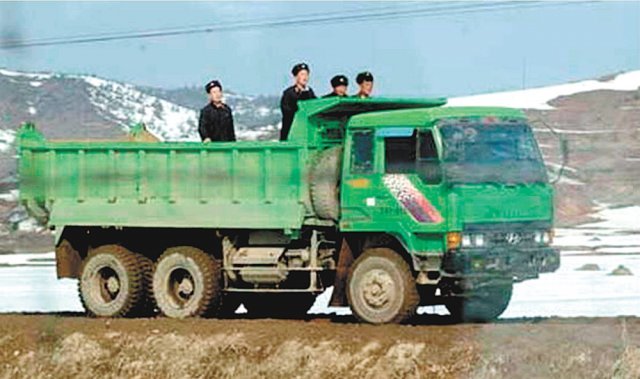 현대 마크가 선명한 덤프트럭을 타고 북한 군인들이 이동하고 있다. 현대라는 영문 상표는 파란 페인트로 지웠다. 2010년 이전 사진으로 촬영 장소는 알려지지 않았다. 출처 현대트럭앤버스 홈페이지