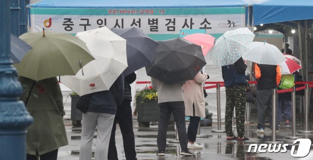 27일 오전 서울 중구 서울역 광장에 마련된 신종 코로나바이러스 감염증(코로나19) 임시 선별검사소에서 시민들이 검사를 받기 위해 빗속에 우산을 쓰고 기다리고 있다. 2021.5.27/뉴스1 © News1