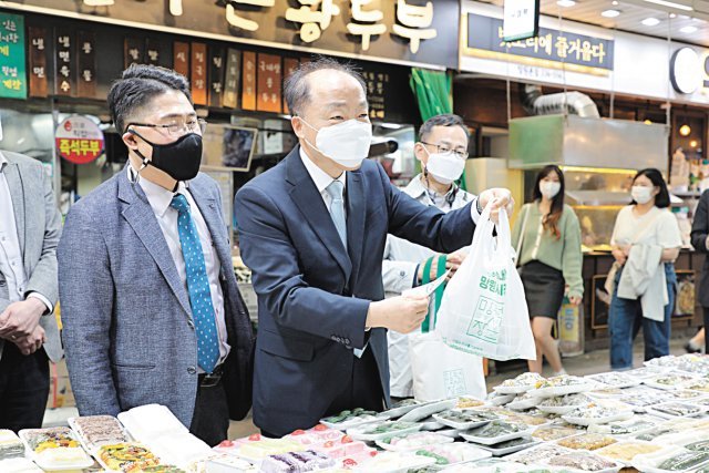 6일 서울망원시장에서 조봉환 소진공 이사장이 장 본 물건을 친환경 비닐봉투에 담고 있다.