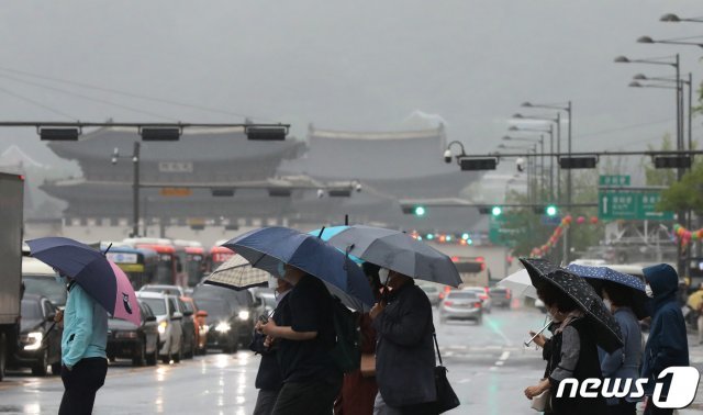 전국 대부분 지역에 ‘황사비’가 내린 25일 오전 서울 종로구 광화문 네거리에서 우산을 쓴 시민들이 출근길 발걸음을 재촉하고 있다… 2021.5.25/뉴스1 © News1