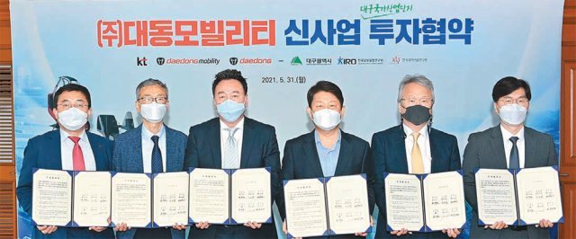 31일 대구 북구 시청 별관 대회의실에서 송재호 KT 부사장과 이승원 ㈜대동모빌리티 대표, 원유현 ㈜대동 총괄사장, 권영진 대구시장, 여준구 KIRO 원장, 김익재 KIST 인공지능·로봇연구소 소장(왼쪽부터)이 e모빌리티 신사업 투자 협약서를 들어보이고 있다. 대구시 제공