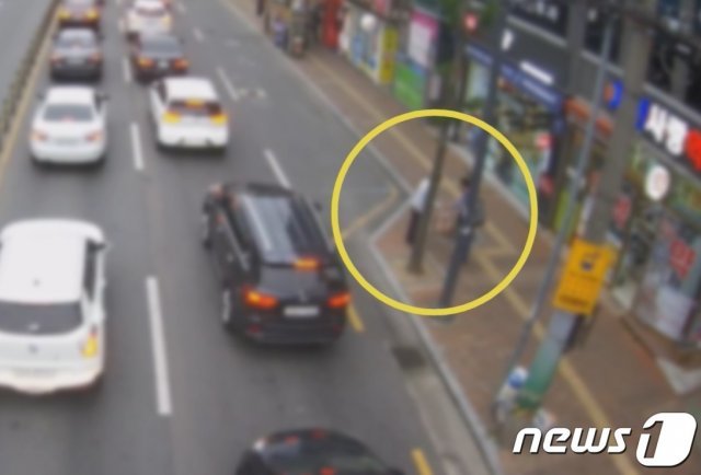 경남 진주의 한 도로에서 보이스피싱범이 피해자로부터 돈을 건네받는 장면의 CCTV 화면. (경남경찰청 제공). © 뉴스1