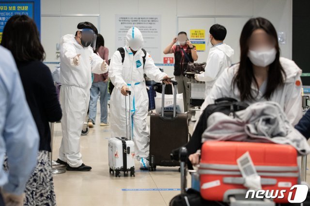 인천국제공항 제1여객터미널 입국장에서 방역관계자들이 입국자들을 안내하고 있다. /뉴스1 © News1