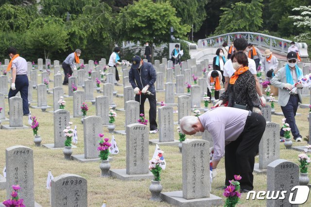 6월 호국보훈의 달을 맞아 서울 동작구 국립서울현충원에 시민들이 묘역에 태극기와 무궁화를 꽂는 봉사를 하고 있다. 2021.6.1/뉴스1 © News1