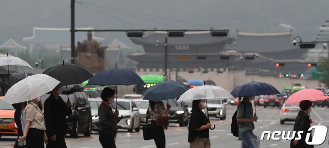 전국 대부분 지역에 비가 내린 3일 오후 서울 종로구 광화문네거리에서 우산을 쓴 시민들이 발걸음을 재촉하고 있다. 2021.6.3/뉴스1 © News1