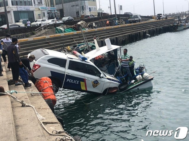 8일 오전 10시21분쯤 서귀포시 안덕면 사계항에서 서귀포해경 화순파출소 순찰차가 어선 위로 추락해 인양 작업이 진행되고 있다.(독자 제공)2021.6.8/뉴스1© News1