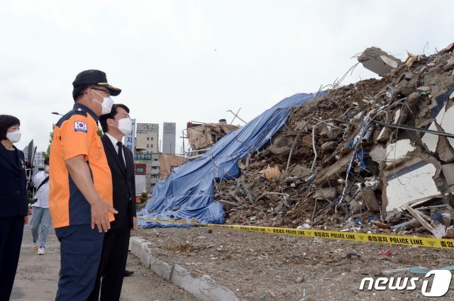 안철수 국민의당 대표가 11일 오전 광주 동구 학동 재개발지역 건물 붕괴 현장을 찾아 소방당국 관계자로부터 사고 경위를 들은 뒤 붕괴 지점을 둘러 보고 있다. 2021.6.11/뉴스1 © News1