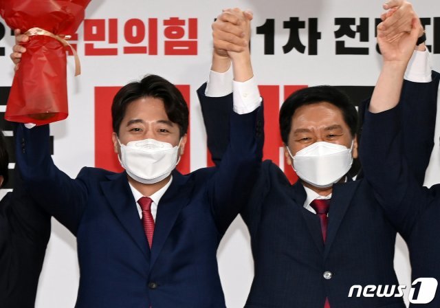 이준석 국민의힘 신임 대표가 11일 오전 서울 영등포구 국민의힘 당사에서 열린 전당대회에서 김기현 원내대표와 손을 맞잡은 채 인사하고 있다. ‘30대·0선’의 이 대표는 역대급 전당대회 흥행을 주도한 끝에 헌정사상 최초의 30대 보수정당 대표에 올랐다. 2021.6.11/뉴스1 © News1
