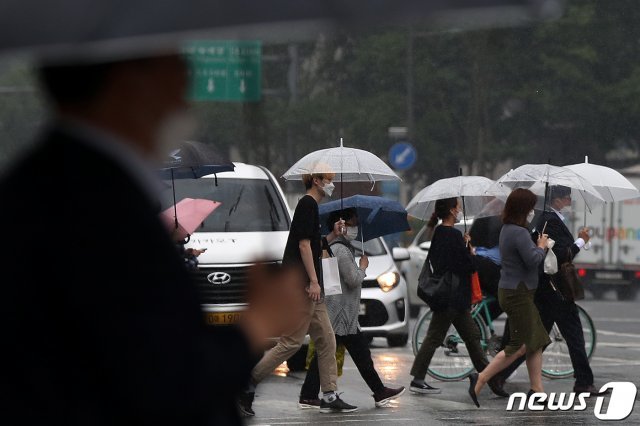 전국 대부분 지역에 비가 내린 3일 오후 서울 종로구 광화문네거리에서 우산을 쓴 시민들이 발걸음을 재촉하고 있다. 2021.6.3/뉴스1 © News1