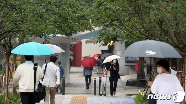 비가 내린 15일 오전 서울 세종로 광화문 네거리 인근에서 우산 쓴 시민들이 발걸음을 재촉하고 있다. 2021.6.15/뉴스1 © News1
